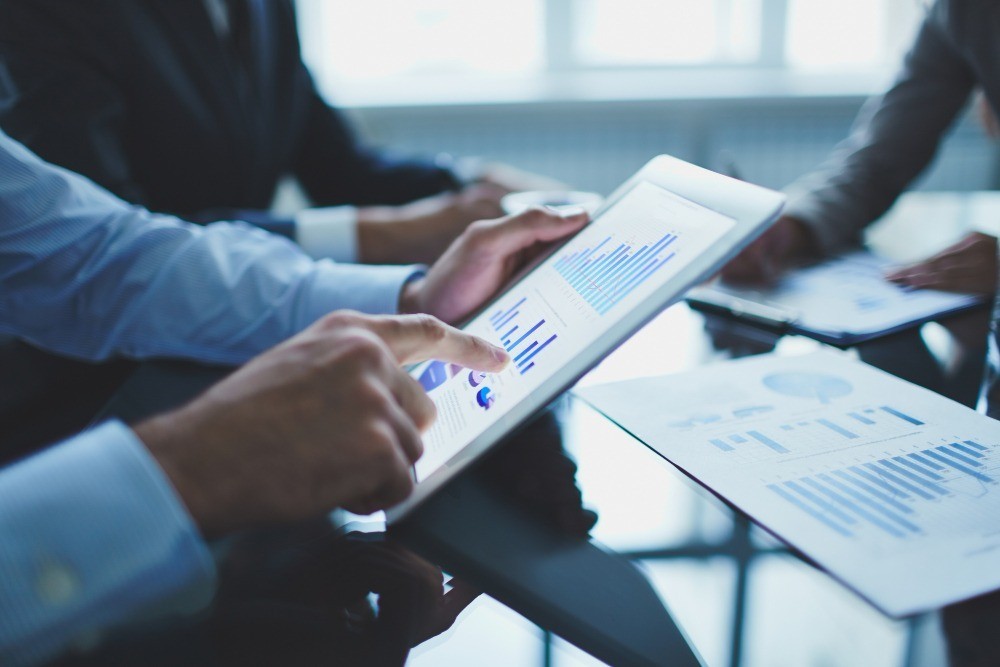 Homme tenant une tablette avec des statistiques